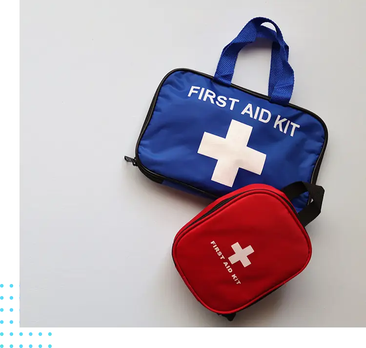 A first aid kit and a red bag on the floor.