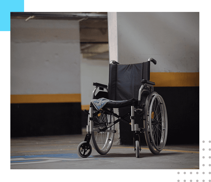 A wheelchair in the middle of a parking lot.