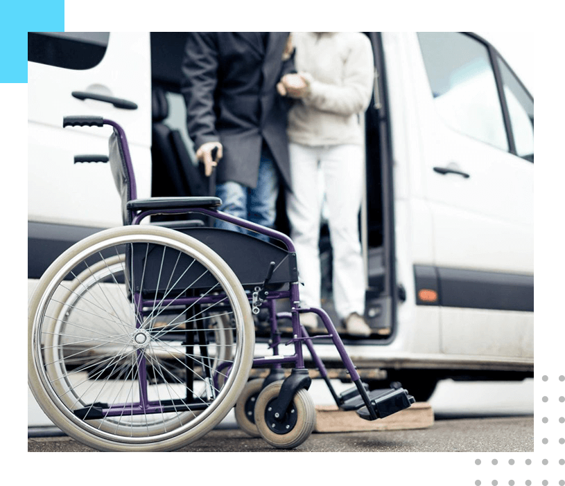 A wheelchair parked in front of a van.