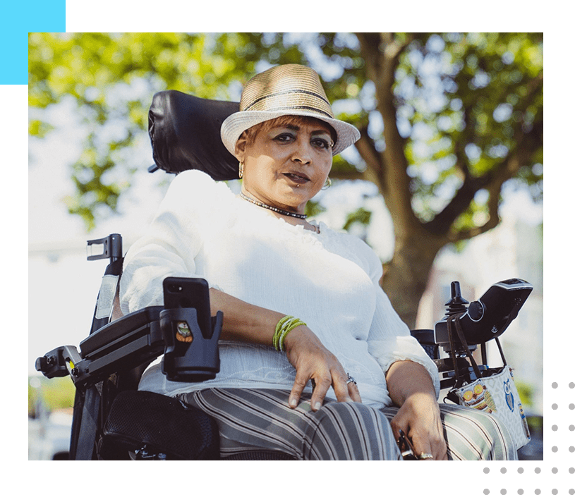 A woman in a wheel chair wearing a hat.